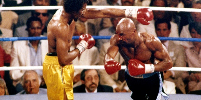 FILE - In this April 1985 file photo, Marvin Hagler, right, and Thomas Hearns fight during the first round of a world championship boxing bout in Las Vegas. Hagler, the middleweight boxing great whose title reign and career ended with a split-decision loss to "Sugar" Ray Leonard in 1987, died Saturday, March 13, 2021. He was 66. (AP Photo, File)