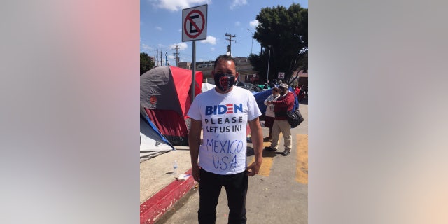 A migrant wears a shirt that reads, 