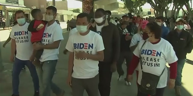 Migrants at the Southern border wear shirts with Biden's campaign logo on them, that say "please let us in." 