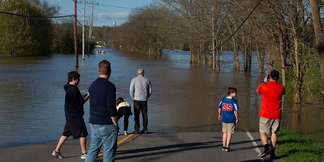 Les résidents de Bellevue enquêtent sur les inondations de la rivière Harpeth dimanche à Nashville, au Tennessee. Les inondations soudaines causées par les tempêtes de la nuit précédente ont provoqué des fermetures de routes dans le quartier de Bellevue.  (Reuters)