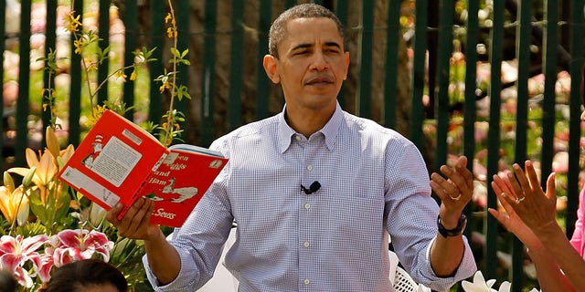 President Obama gets a round of applause after reading "Green Eggs and Ham," by Dr. Suess, for a group of children and his family, first lady Michelle Obama (R) and daughters Malia Obama (L), 11, and Sasha Obama, 8, during the Easter Egg Roll at the White House April 5, 2010, in Washington, D.C.