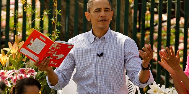 President Obama gets a round of applause after reading "Green Eggs and Ham," by Dr. Suess, for a group of children and his family, first lady Michelle Obama (R) and daughters Malia Obama (L), 11, and Sasha Obama, 8, during the Easter Egg Roll at the White House April 5, 2010, in Washington, D.C.