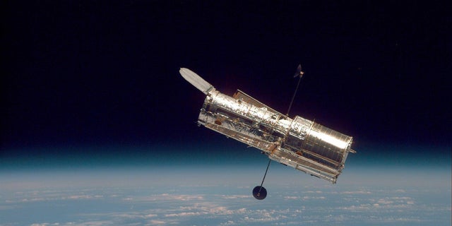 El telescopio espacial Hubble se cierne sobre la frontera de la Tierra en esta imagen tomada en 1997 después de la segunda misión de servicio del Hubble.