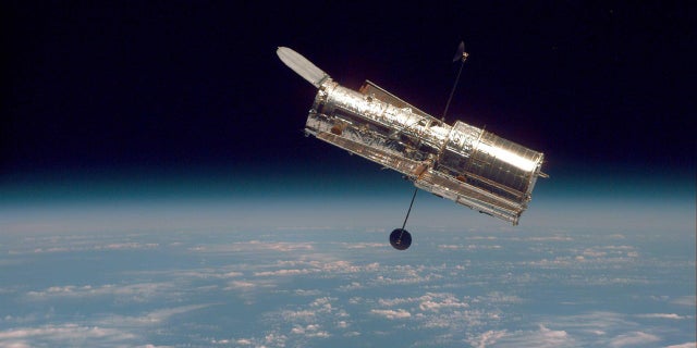 The Hubble Space Telescope hovers at the boundary of Earth and space in this picture, taken after Hubble's second servicing mission in 1997.