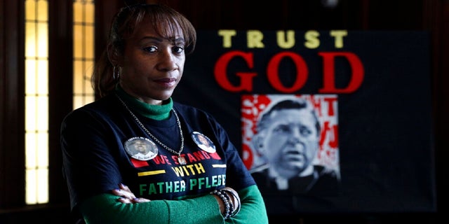 Activist Pam Bosley poses for a portrait infront of a portraiture of Father Michael Pfleger, inside the St. Sabina Catholic Church on March 4. (AP)