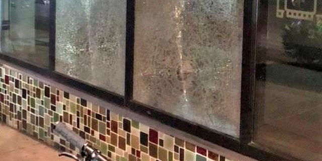 This Friday, March 12, 2021, photo shows smashed windows left behind by people inside the perimeter of a march by a group of about 100 hundred protesters Friday night in Portland, Ore. (Portland Police Department via AP)