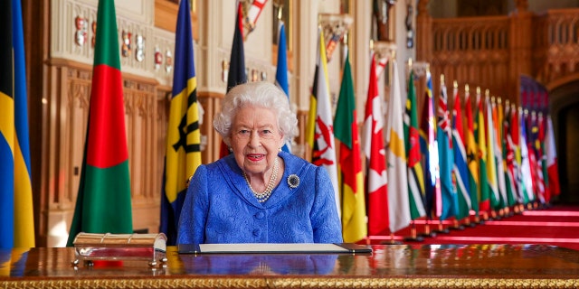 In this photo made available Sunday March 7, 2021, Britain's Queen Elizabeth II poses for a photo while signing her annual Commonwealth Day Message inside St George's Hall at Windsor Castle, England, Friday March 5, 2021.