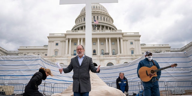 WASHINGTON, DC - APRIL 10: Rev. Patrick Mahoney, director of the Christian Defense Coalition, kneels in prayer as he livestreams a Good Friday service on the grounds of the U.S. Capitol on April 10, 2020 in Washington, DC. Amidst the COVID-19 pandemic, Christians around the globe will mark the Easter holiday. (Photo by Drew Angerer/Getty Images)