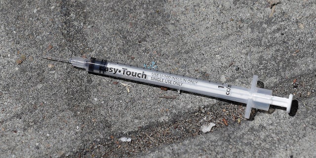 In this file photo from Thursday, May 10, 2018, a used syringe is shown on a sidewalk in San Francisco. 