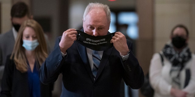 Rep. Steve Scalise, R-La., the House minority whip, dons a messaging mask following a GOP strategy session, at the Capitol in Washington, Tuesday, March 9, 2021.