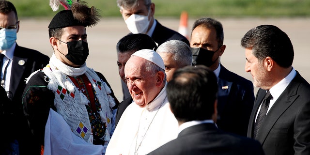 Iraqi Kurds officials welcome Pope Francis, center, as he arrives at Irbil airport, Iraq, Sunday, March 7, 2021. (Associated Press)