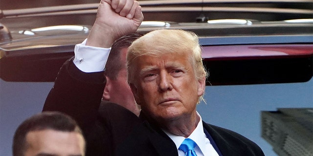 Former U.S. President Donald Trump acknowledges people as he gets in his SUV outside Trump Tower
