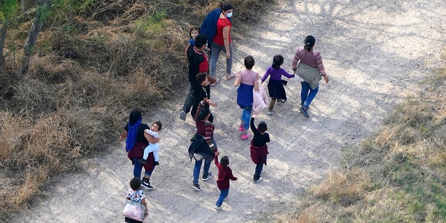 Des migrants marchent sur un chemin de terre après avoir traversé la frontière américano-mexicaine, le mardi 23 mars 2021, à Mission, au Texas.  Une vague de migrants à la frontière sud-ouest met l'administration Biden sur la défensive.  Le chef de la sécurité intérieure a reconnu la gravité du problème, mais a insisté sur le fait qu'il était sous contrôle et a déclaré qu'il ne relancerait pas la pratique de l'ère Trump d'expulser immédiatement les adolescents et les enfants.  (Photo AP / Julio Cortez)