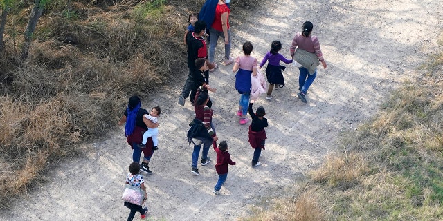 Migrants walk on a dirt road after crossing the U.S.-Mexico border, Tuesday, March 23, 2021, in Mission, Texas. A surge of migrants on the Southwest border has the Biden administration on the defensive. The head of Homeland Security acknowledged the severity of the problem but insisted it's under control and said he won't revive a Trump-era practice of immediately expelling teens and children. (AP Photo/Julio Cortez)