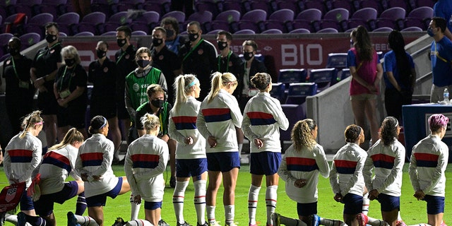 Some members of the American team kneel while playing the national anthem ahead of a SheBelieves Cup women's soccer match against Canada, Thursday, February 18, 2021, in Orlando, Florida (AP Photo / Phelan M. Ebenhack)