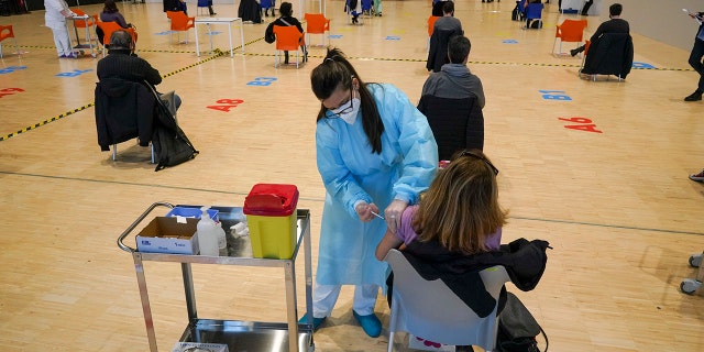 March 10, 2021: Health workers administer doses of the AstraZeneca vaccine against COVID-19 inside the convention center known as "La Nuvola", The Cloud, in Rome.