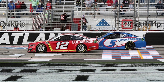Blaney (12) and Larson (5) cross the start/finish line with eight laps left at Atlanta.