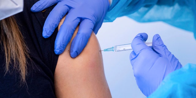 A police officer receives an injection with AstraZeneca's COVID-19 vaccine in Munich, Germany on March 2, 2021.  (Sven Hoppe/dpa via AP, File)