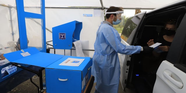 Coronavirus patients cast their ballots Tuesday at a special drive-through polling station in Israel. (Eitan Elhadez/TPS)