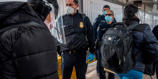 Migrants approach the American border on Gateway International Bridge in Brownsville, Texas, on March 2, 2021. President Biden announced he was ending the Migrant Protection Protocol (MPP) enacted under President Trump that sent asylum seekers back to Mexico as they awaited their trial dates. (SERGIO FLORES/AFP via Getty Images)