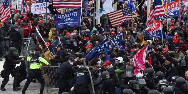 TOPSHOT - Trump supporters clash with police and security forces as they push barricades to storm the US Capitol in Washington D.C on January 6, 2021. - Demonstrators breeched security and entered the Capitol as Congress debated the 2020 presidential election Electoral Vote Certification. (Photo by ROBERTO SCHMIDT / AFP) (Photo by ROBERTO SCHMIDT/AFP via Getty Images)