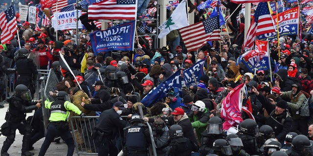 TOPSHOT - Trump supporters clash with police and security forces as they push barricades to storm the US Capitol in Washington D.C on January 6, 2021. - Demonstrators breeched security and entered the Capitol as Congress debated the 2020 presidential election Electoral Vote Certification. (Photo by ROBERTO SCHMIDT / AFP) (Photo by ROBERTO SCHMIDT/AFP via Getty Images)