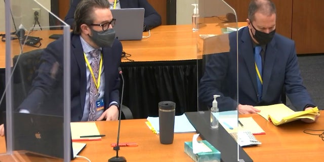 In this image taken from video, defense attorney Eric Nelson, left, and defendant former Minneapolis police officer Derek Chauvin, right, confer before Hennepin County Judge Peter Cahill presides over jury selection on Monday. (AP/Court TV)