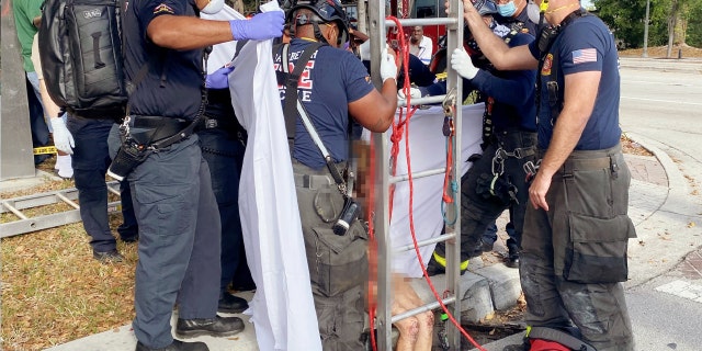 Only a pair of scuffed, bloody knees can be seen on Lyndsey Kennedy, 43, before she’s loaded onto a stretcher en route to a Florida hospital for medical treatment.