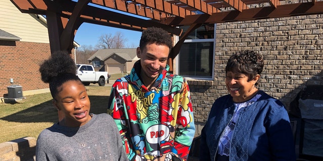 March 7, 2021: Brilee Carter, left,13, and Cobe Calhoun, 17, share a laugh with their great-grandmother, Doris Rolark, outside Rolark's daughter's home in Monroe, Ohio. 