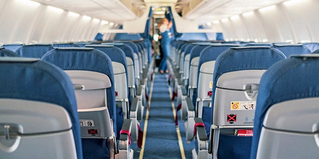 The interior of an empty aircraft cabin.  Professor Ed Galia advises you to be aware of your surroundings before boarding your seat while boarding.