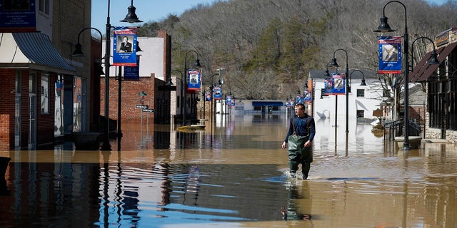 Brad Newnam crosses a flooded East Main Street while checking on businesses in the area in downtown Beattyville, Ky., on Tuesday. Heavy rains caused the Kentucky River to flood most of downtown Beattyville. (AP/Lexington Herald-Leader)