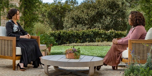 Meghan Markle being interviewed by Oprah Winfrey in an outdoors setting