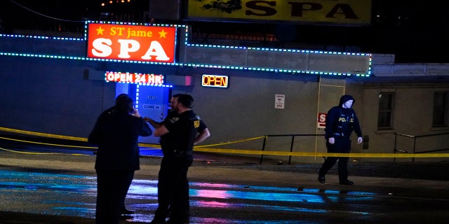 Law enforcement officials confer outside a massage parlor following a shooting on Tuesday in Atlanta. (AP)