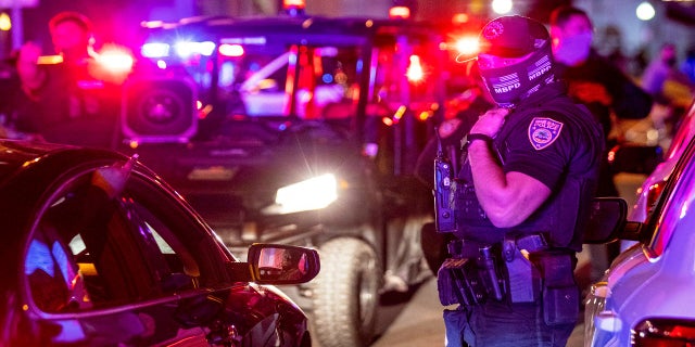 Miami Beach Police arrive on the scene to disperse a crowd that formed near Seventh Street and Alton Road after crowds were sent away from Ocean Drive in Miami Beach, Fla., on Sunday. (AP/Miami Herald)
