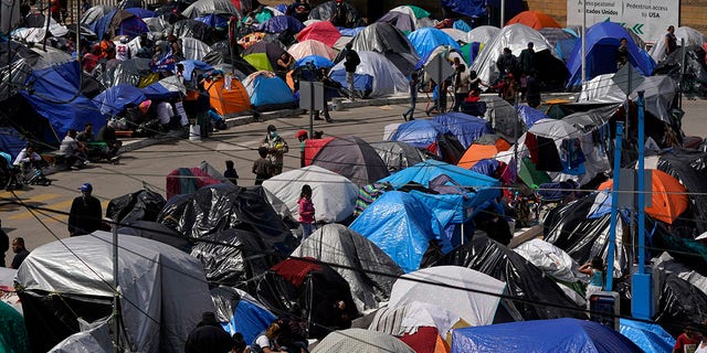 A makeshift camp of migrants sits at the border port of entry leading to the United States, Wednesday, March 17, 2021, in Tijuana, Mexico. The migrant camp shows how confusion has undercut the message from U.S. President Joe Biden that it’s not the time to come to the United States. Badly misinformed, some 1,500 migrants who set up tents across the border from San Diego harbor false hope that Biden will open entry briefly and without notice. (AP Photo/Gregory Bull)
