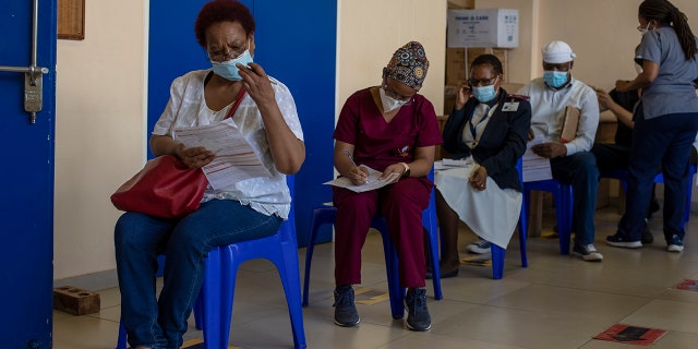 Maggie Sedidi, left, a 59-year-old nurse at Soweto's Chris Hani Baragwanath hospital, reads a medical questioner before receiving her dose of the Johnson & Johnson COVID-19 vaccine at a vaccination center in Soweto, South Africa, Friday, March 5, 2021.
