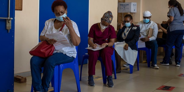 Maggie Sedidi, left, a 59-year-old nurse at Soweto's Chris Hani Baragwanath hospital, reads a medical questioner before receiving her dose of the Johnson &amp; Johnson COVID-19 vaccine at a vaccination center in Soweto, South Africa, Friday, March 5, 2021. 