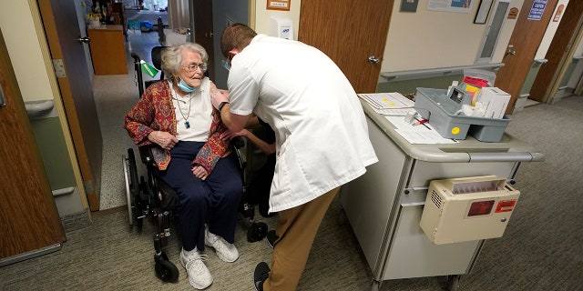 In this Jan. 8, 2021, file photo, Jean Allen, 96, left, receives the first shot of the Pfizer vaccination for COVID-19, from a Walgreens Pharmacist, right, at Queen Anne Healthcare, a skilled nursing and rehabilitation facility in Seattle.