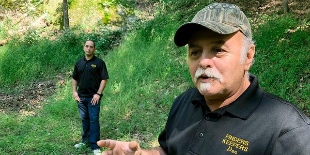 This Sept. 20, 2018 file photo, Dennis Parada, right, and his son Kem Parada stand at the site of the FBI's dig for Civil War-era gold in Dents Run, Pennsylvania. (AP Photo/Michael Rubinkam, File)