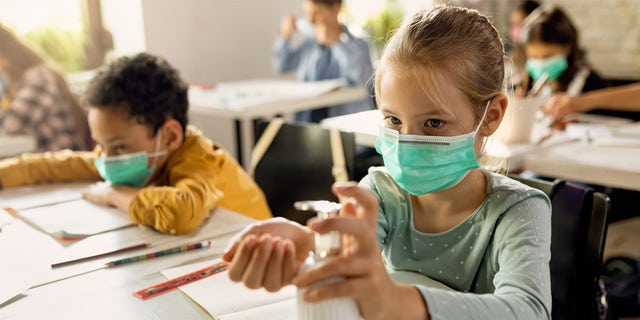 Elementary school students wearing masks in a classroom. 