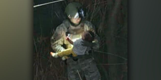 A member of the South Texas Special Operations Group holds a six-month-old baby that was rescued out of the Rio Grande River on March 16. 