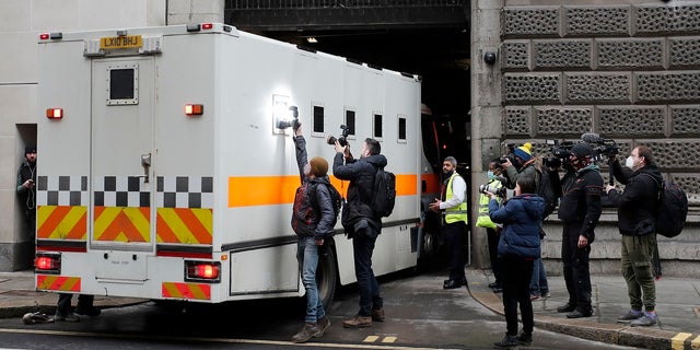 Journalists try to take pictures of the inside of a prison van moving into the Old Bailey on Tuesday. (AP)