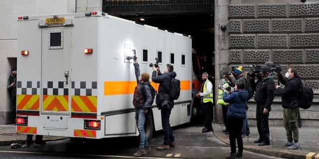 Journalists try to take pictures of the inside of a prison van moving into the Old Bailey on Tuesday. (AP)