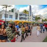 Despite the coronavirus, spring breakers return to South Beach and walk along Ocean Drive that is closed to traffic on Thursday, March 12, 2021. Miami Beach officials are imposing an emergency 8 p.m.-6 a.m. curfew effective immediately, saying large, out-of-control spring break crowds crammed the beaches, trashed some restaurant properties and brawled in the streets. Tourists and hotel guests are being told to stay indoors during the curfew hours. (Al Diaz/Miami Herald via AP)