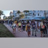 Spring break tourists walk alongside Ocean Drive in Miami Beach, Florida, Sunday night, March 21, 2021. An 8 p.m. curfew has been extended in Miami Beach after law enforcement worked to contain unruly crowds of spring break tourists. (Carl Juste/Miami Herald via AP)