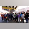 People surround a car as it arrives carrying food donations at a makeshift camp for migrants seeking asylum in the United States at the border crossing Friday, March 12, 2021, in Tijuana, Mexico. The Biden administration hopes to relieve the strain of thousands of unaccompanied children coming to the southern border by terminating a 2018 Trump-era order that discouraged potential family sponsors from coming forward to house the children. (AP Photo/Gregory Bull)
