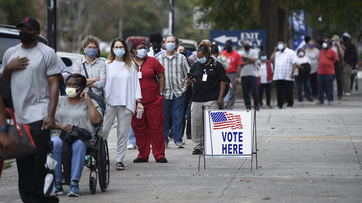FILE - In this Oct. 12, 2020, file photo, people wait in line for early voting at the Bell Auditorium in Augusta, Ga. The sweeping rewrite of Georgia's election rules that was signed into law by Republican Gov. Brian Kemp Thursday, March 25, 2021, represents the first big set of changes since former President Donald Trump's repeated, baseless claims of fraud following his presidential loss to Joe Biden. Georgia's new, 98-page law makes numerous changes to how elections will be administered, including a new photo ID requirement for voting absentee by mail. (Michael Holahan/The Augusta Chronicle via AP, File)Explaining Us Voting Bills Georgia 1