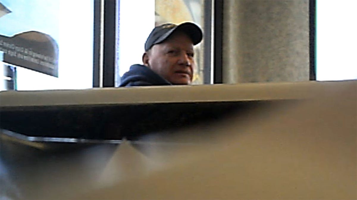 Philip Snider sits inside Burger King, wearing a hat.