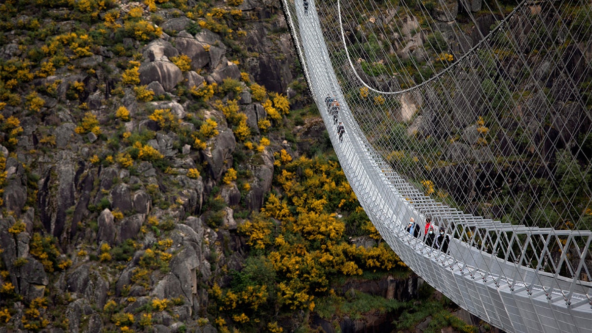 People walk on the world's longest pedestrian suspension bridge '516 Arouca', now open for local residents in Arouca, Portugal.