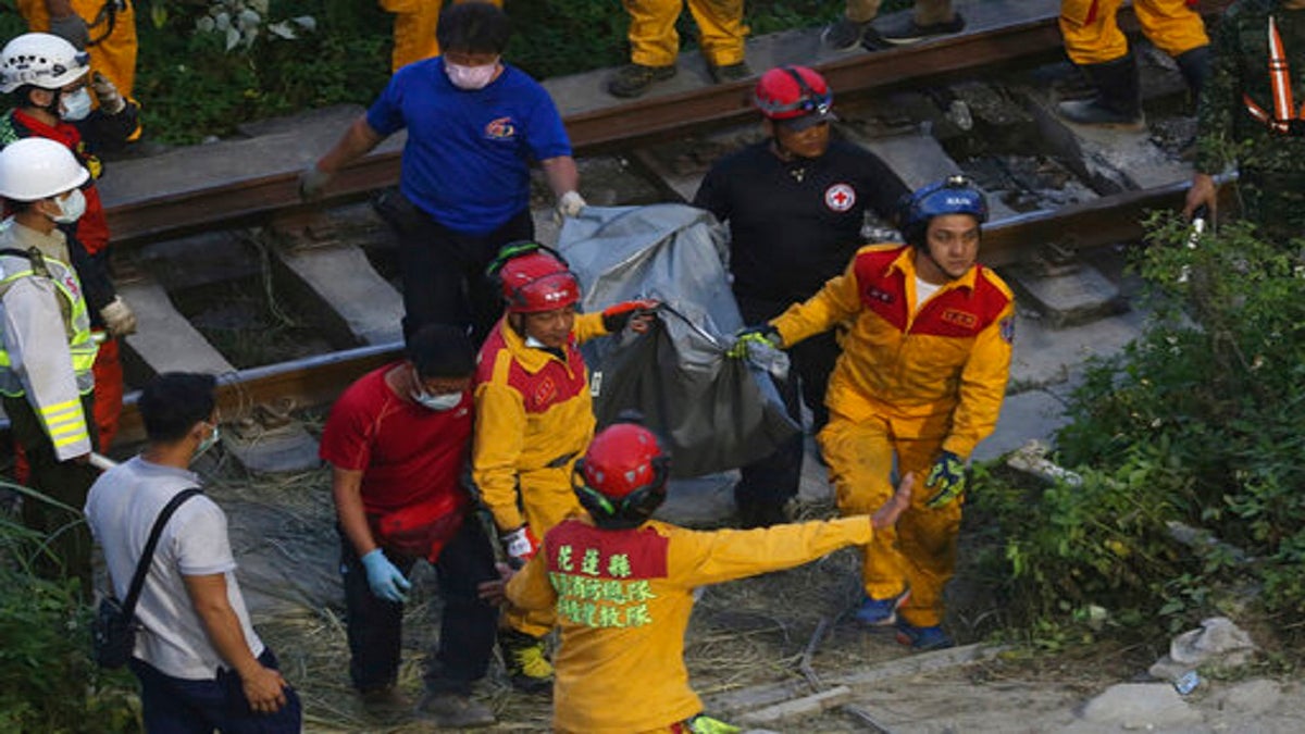 Rescue workers recover a body from a derailed train near the Taroko Gorge area in Hualien, Taiwan, on Friday. (AP)